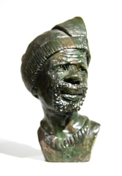 Photo 1 de l'œuvre "Männerbüste mit Kopfbedeckung von Gladmore Reza - Afrikanische Verdite-Steinbüste (Shona-Skulpturen-Kunst aus Simbabwe)" par Artist Wanted sur art24