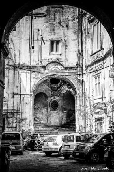 Image 1 of the artwork "Enfant lisant dans une cour intérieur du Rione de la Sanita" by Sylvain Blanchoud on art24